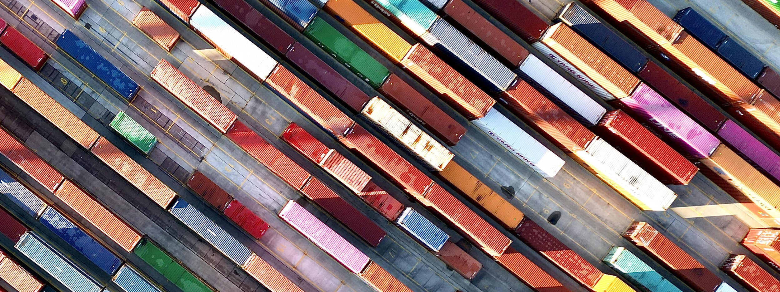 Aerial view of colorful cargo container stacks in shipping port
