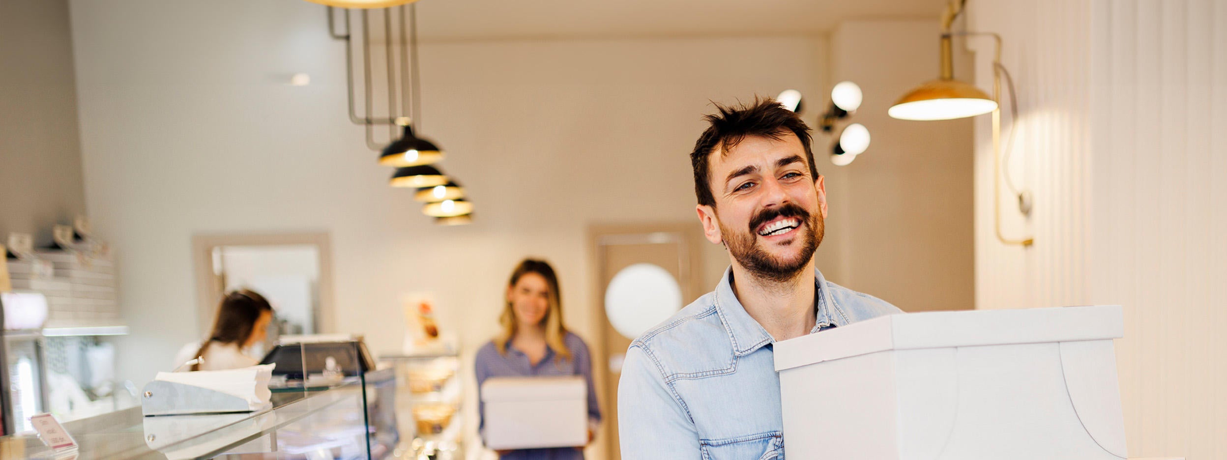 People carrying cake boxes in a bakery