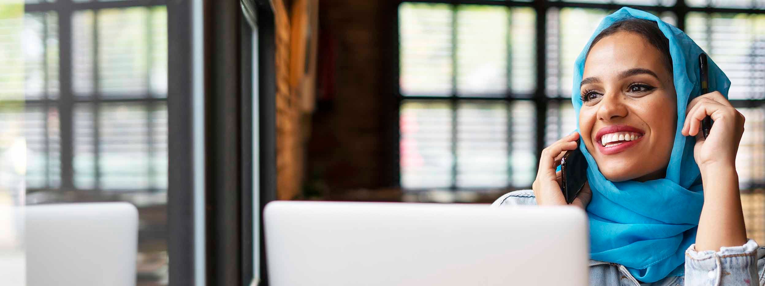 woman on phone with laptop in-front